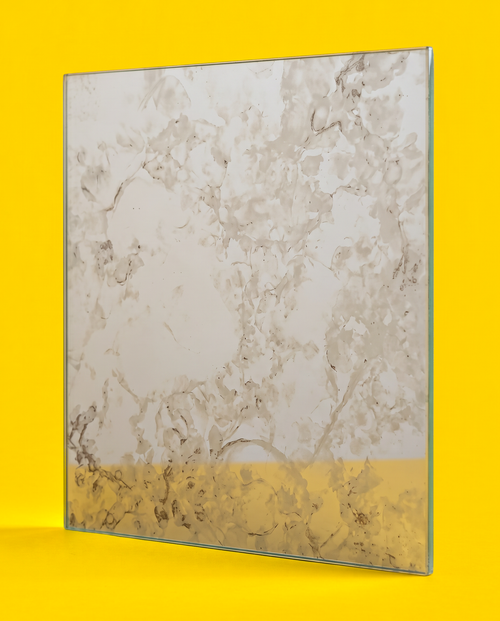 Antique mirror glass panel in the Silver Night pattern, pale silver grey with soft clouds and fine dark veins, on a yellow background