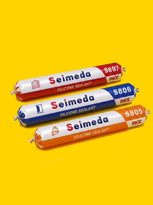 Three Seimeda neutral cure silicone sealant sausage packs, S807 red, S806 blue and S805 orange, on a flat yellow ground