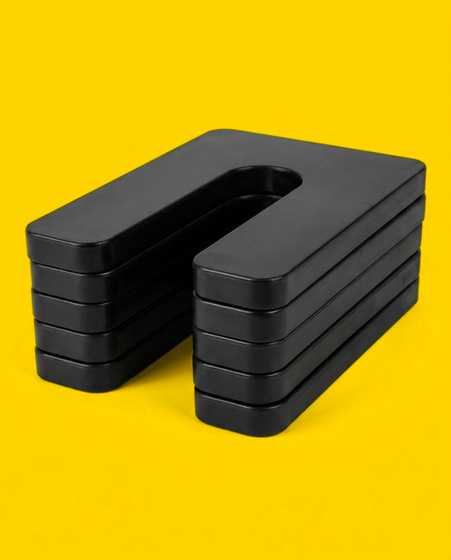 Stack of five black horseshoe shims with the slots aligned, showing the consistent gauge of each layer